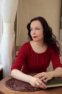kirjailija Mila Ter&auml;s Oskarin piha -kahvilassa, punainen mekko, valkoinen verho